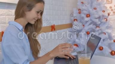 现代笔记本电脑附近的金发女人微笑<strong>喝果汁</strong>